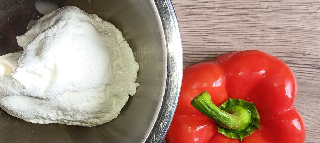 Frischk&auml;se-&auml;hnlicher Kefir (lange im K&uuml;hlschrank abgetropft) in einer Edelstahlsch&uuml;ssel � und rechts eine rote Paprika.